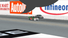 two race cars on a track in front of a sign that says autotrader