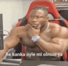 a shirtless man is sitting in front of a computer with the words he kanka öyle mi olmus ya on the screen .