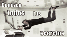 a man in a suit is flying through the air while using a laptop computer .