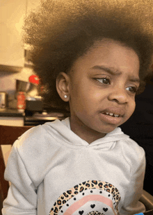 a little girl wearing a white shirt with a leopard print on it