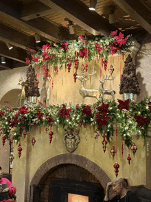 a fireplace with christmas decorations and a deer on top