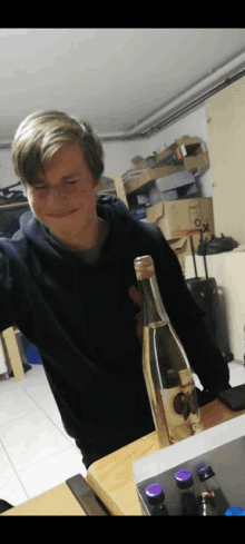 a young man is holding a bottle with a cork that says gx