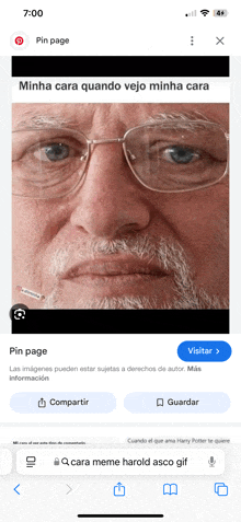 a phone screen shows a picture of an older man with glasses and a beard