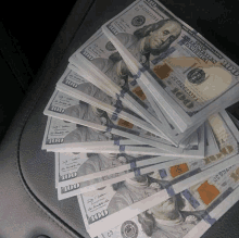 several stacks of 100 dollar bills are on a car seat