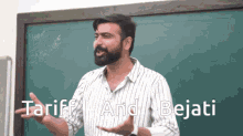 a man with a beard stands in front of a blackboard with the words " tariff and bejati " on it