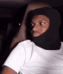 a man wearing a ski mask is sitting in a car .