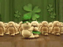 a group of stuffed animals are dancing in front of a clover on a wall