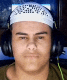 a close up of a man wearing headphones and a white headband .