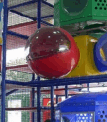 a red ball is hanging from the ceiling of a playground .