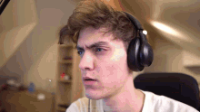 a young man is wearing headphones and making a funny face