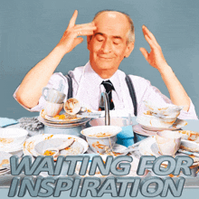 a man is sitting at a table with dirty dishes and the words waiting for inspiration