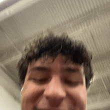 a close up of a man 's face with a ceiling in the background