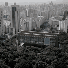 a black and white photo of a city with a large building in the foreground that says ' allianz ' on the side