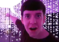 a man with a surprised look on his face in front of purple lights