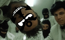 a man with a cartoon face on his head is surrounded by people wearing masks