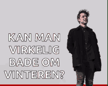 a man in a black coat is standing in front of a sign that says kan man virkelig bade om vinteren