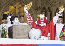 a clown is holding a piece of bread in front of a group of people