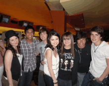 a girl wearing a vampire diaries shirt poses for a picture with her friends