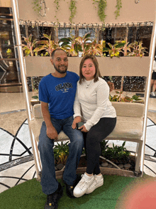 a man in an orlando shirt sits next to a woman on a bench