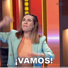 a woman in a blue jacket says vamos in spanish