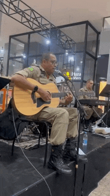 a man playing a guitar and singing into a microphone