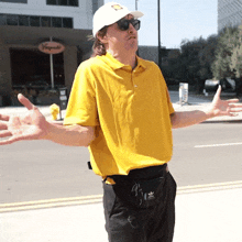 a man wearing a yellow shirt and a white hat is standing in front of a building that says vingate