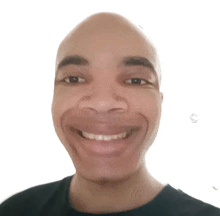 a man with a bald head and a black shirt is smiling