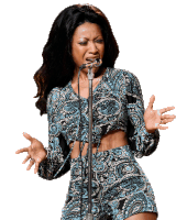 a woman is singing into a microphone with her hands outstretched .