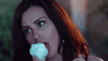 a woman licks an ice cream cone with her tongue out