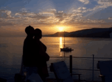 a couple looking at a sunset over the ocean