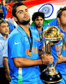 a man holding a trophy with the word india on it