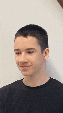 a young man wearing a black shirt looks at the camera