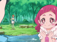 a little girl with pink hair is standing next to a river in a forest .