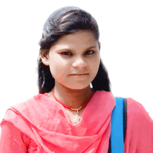 a woman wearing a pink top and a necklace with a pendant that says ' shree ' on it