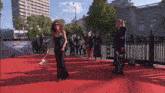 a woman in a black dress stands on a red carpet in front of a sign that says european union