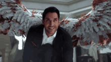 a man in a suit has bloody angel wings