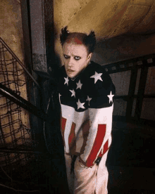 a man with a red and white mohawk is wearing an american flag sweater .