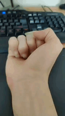 a close up of a person 's fist in front of a computer keyboard