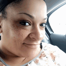 a woman with freckles on her face smiles for the camera