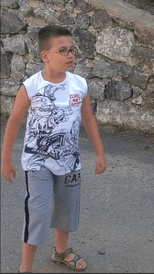 a young boy wearing glasses and a white shirt that says clubs of the world