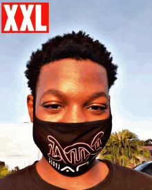 a man wearing a face mask is standing in front of a xxl logo