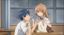 a boy and a girl are sitting at a table with xrecorder written in the corner