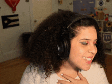 a woman wearing headphones is smiling in front of a wall with a flag that says ' puerto rico ' on it