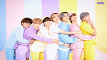 a group of boys are hugging each other in front of a colorful background that says festa