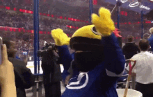 a mascot wearing a blue jersey with the letter j on the back