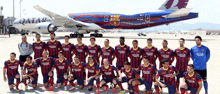 a group of soccer players are posing in front of a qatar plane