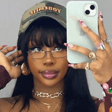 a woman wearing a hat that says timeboy takes a picture of herself with her phone