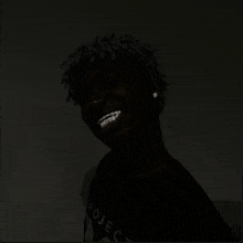 a man with braces on his teeth is smiling in a dark room .