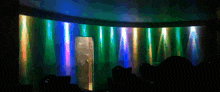 a dark room with a rainbow of lights coming out of a door