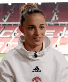 a woman wearing a white manchester united sweatshirt